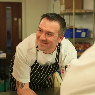 Paul Devoy, Executive Head Chef, smiling in the Fahrenheit kitchen