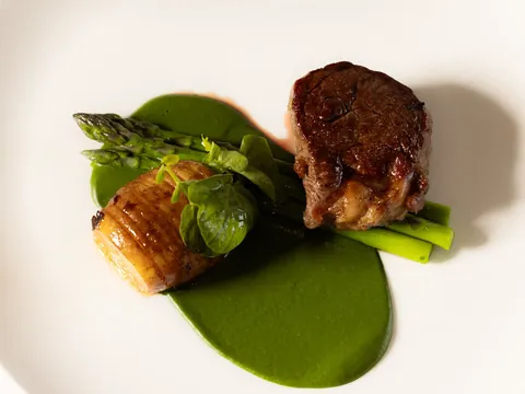 Beef fillet with hasselback potato and asparagus on green purée