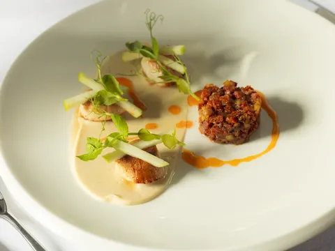 Seared scallop with pea shoots and tartare, on a creamy purée