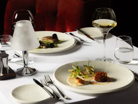 Table setting with starter plates and glasses of white and red wine